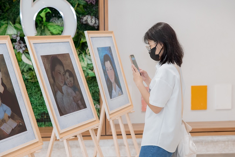 A person wearing a face mask taking a picture of herDescription automatically generated